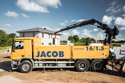 Ein LKW von JACOB CEMENT BAUSTOFFE in Großaufnahme auf einer Baustelle