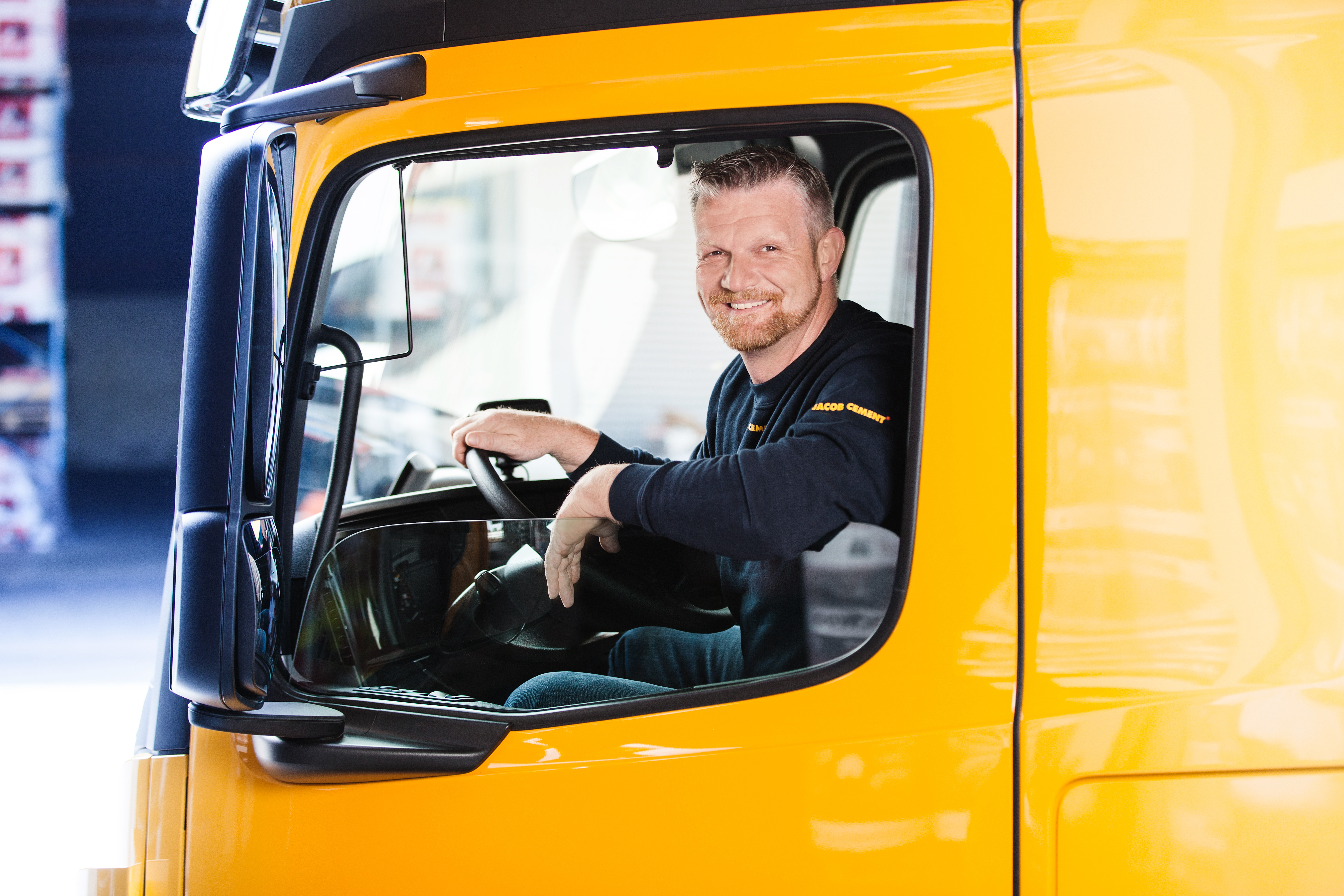 Foto eines Mitarbeiters von JACOB CEMENT BAUSTOFFE am Steuer eines Lkw